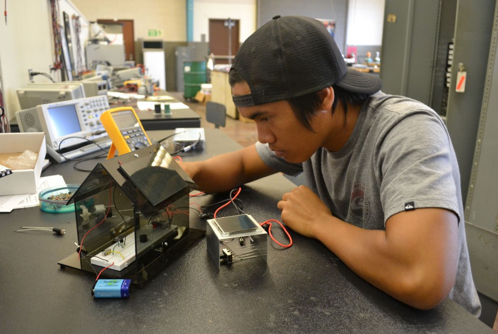 Philip Daquep, a student in Hawai‘i Community College’s Electronics Technology program, works with a solar battery charger built by students at the college.