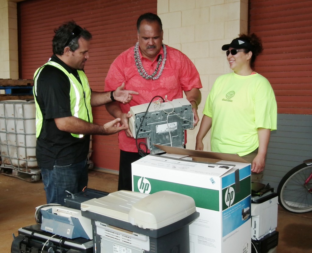 Nikolas Nikolaidis, president of T&N Recycling Services, Mayor Bernard Carvalho, Jr. and Laura Kelly, county recycling specialist, examine an electronic item that was dropped off at the Kaua'i Resource Center during the first day of the eWaste Program.