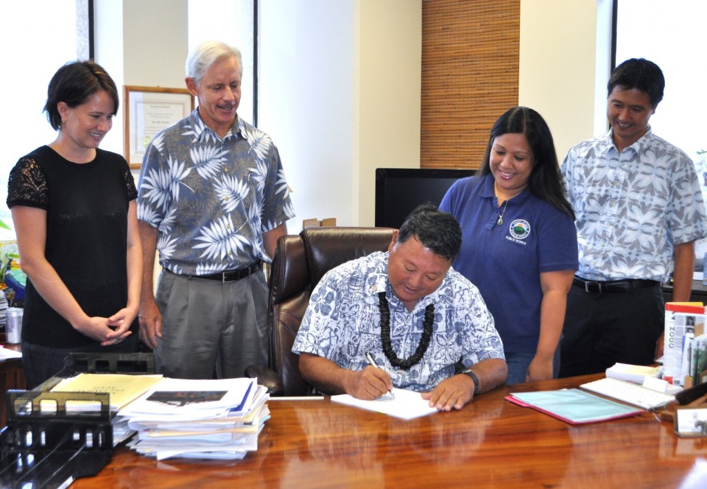 Mayor Arakawa signs revisions to the Subdivision Code; the Mayor is joined by Department of Public Works Director David Goode (left of Mayor), Deputy Director Rowena Dagdag-Andaya (right of Mayor), and staff engineers Lesli Otani (far left) and Lance Nakamura (far right).
