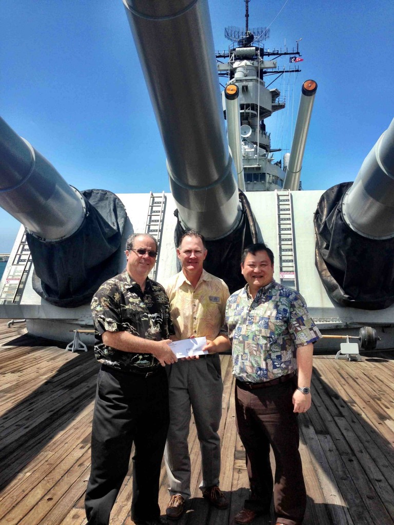 Michael Carr, President & COO, Battleship Missouri Memorial (left) and Dan Parsons, Education Director, Battleship Missouri Memorial (center), accept a $10,000 charitable grant from Wayne Suehiro, Senior VP and Area Manager Pearlridge Branch, First Hawaiian Bank (right), which will be used to subsidize educational programs at the USS Missouri for students from Title I schools. Photo Credit to the USS Missouri Memorial Association.
