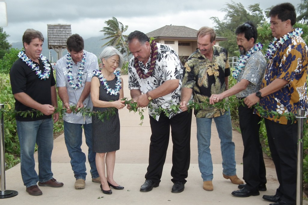 Officials untie the maile lei during the blessing of 3 new segments of Ke Ala Hele Makalae, Kaua'i’s multi-use path. From left: Steve Baginski, president and CEO, Kaikor Construction Co.; Bill McCune, project manager, Earthworks Pacific, Inc.; Council member JoAnn Yukimura; Mayor Bernard Carvalho, Jr.; Jeff Fisher, president, Earthworks Pacific, Inc.; Steve Kyono, vice president and Kaua'i office manager, SSFM International, Inc.; and Parks and Recreation Director Lenny Rapozo.