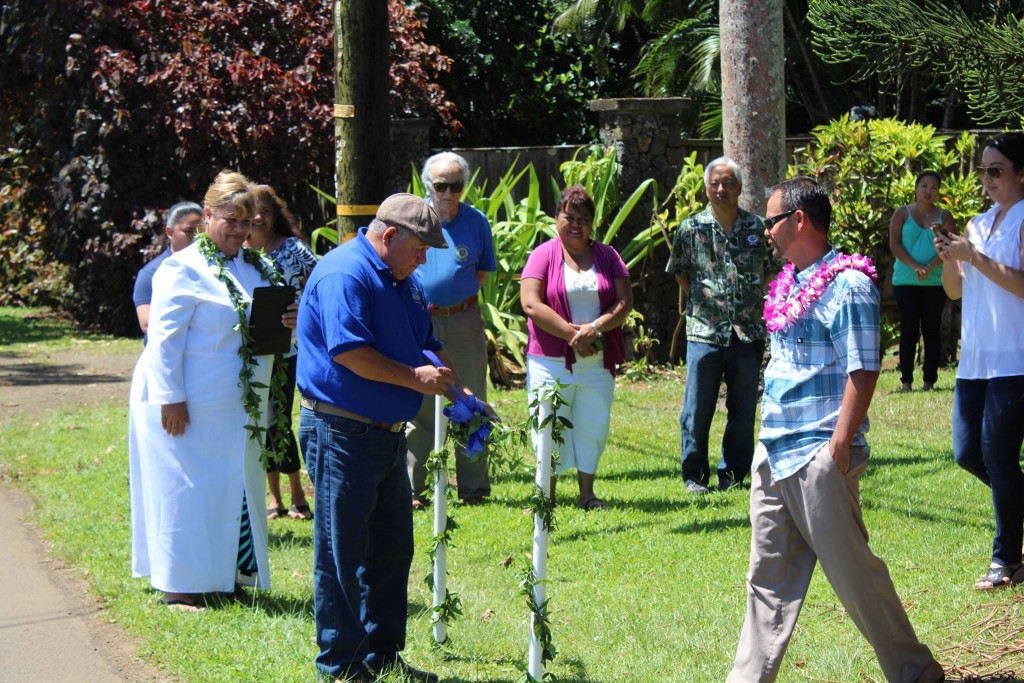 DOW Waterworks Inspector Alfred Levinthol unties the maile lei to complete the blessing of the Kolo Road Main Replacement project. The project is scheduled to start July 6.